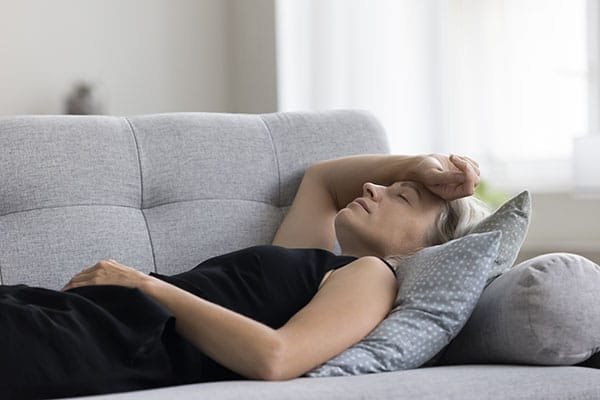 Peaceful serene mature woman lying on back on sofa 1